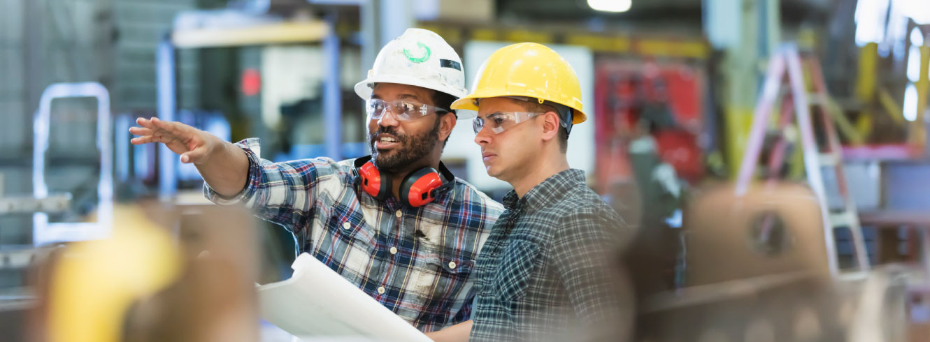 Two men in hard hats at a worksite. 