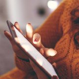 Close up of a person's hands tapping on a phone. 