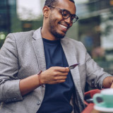 A man holding a credit card and smiling. 