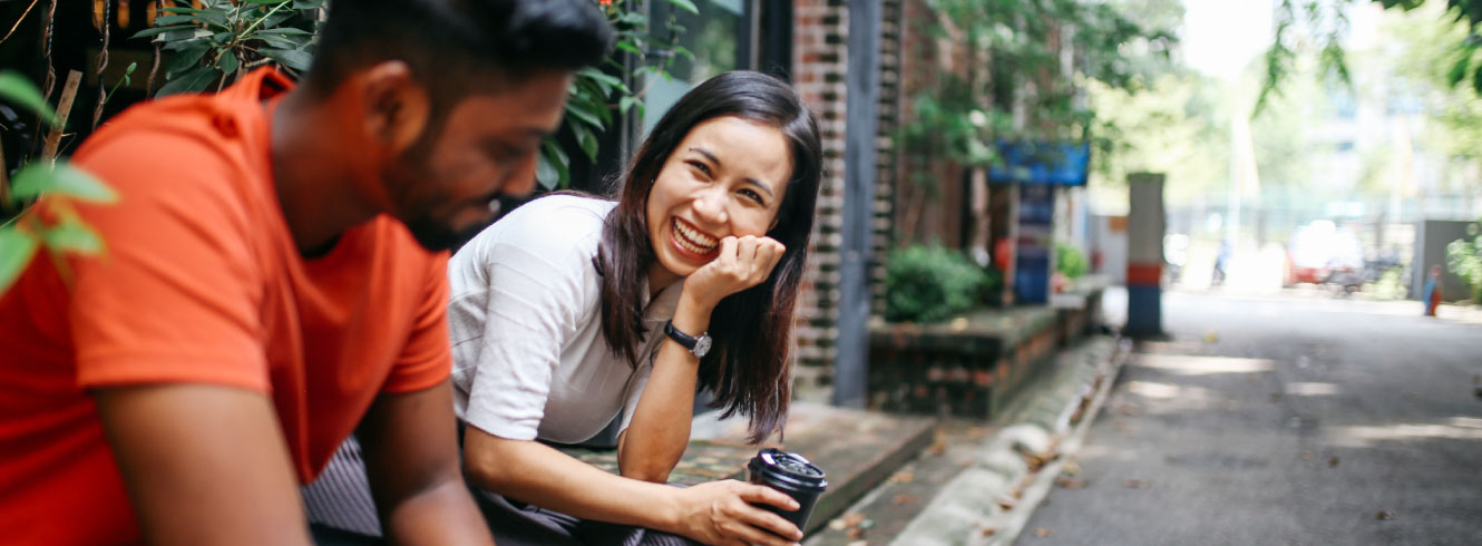 Two friends sitting outside and laughing.