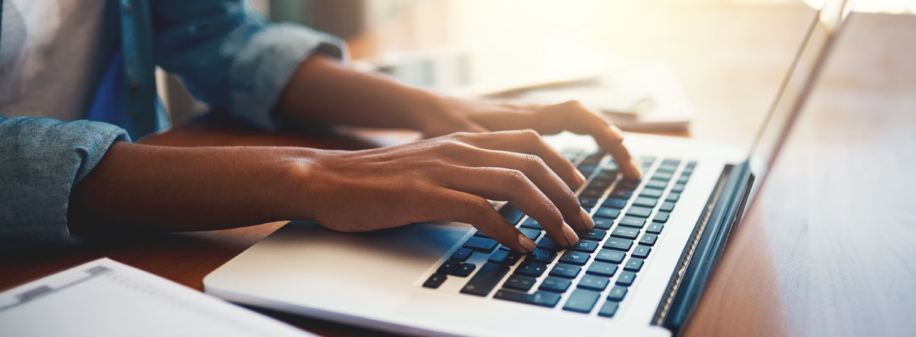 Close up of hands at a laptop keyboard.