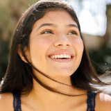 Young woman smiling looking off in the distance. 