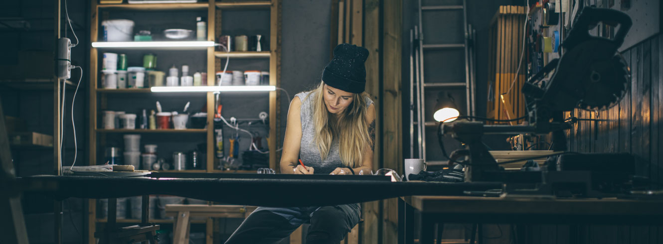 A woman working in a dark workshop.