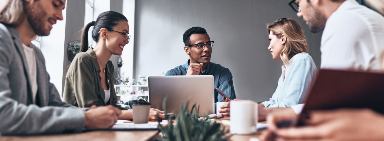 A group of young professionals gathered around a meeting table.